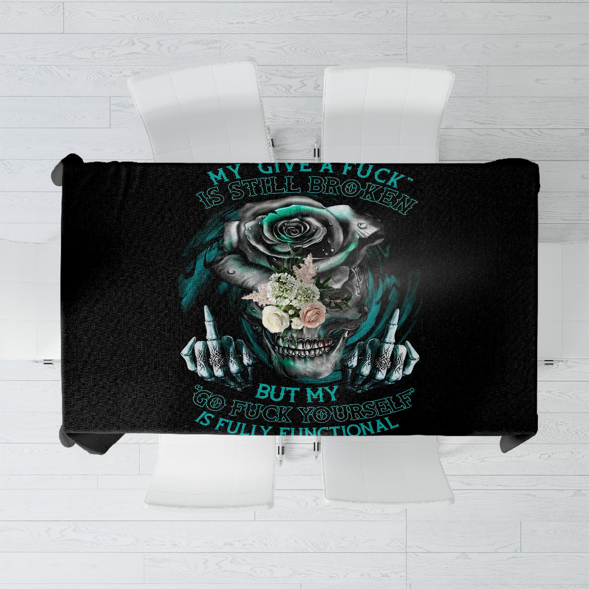 Black tablecloth showing teal skull-and-rose artwork with turquoise text.