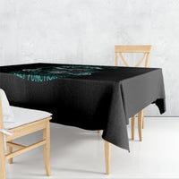Black tablecloth corner draped down the side with teal graphic text.