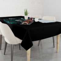 Black tablecloth on dining table with teal graphic text and table decor.