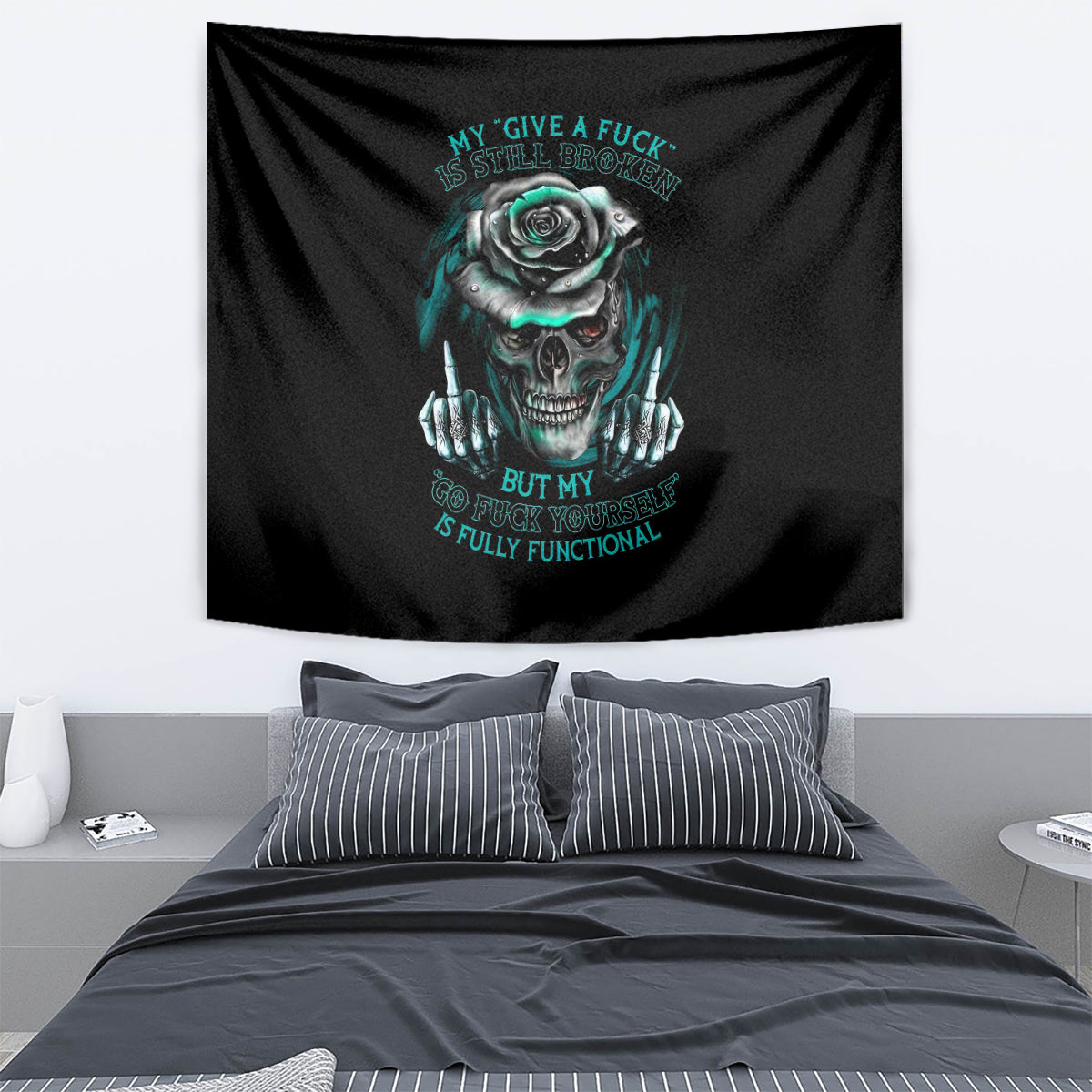 Black wall tapestry with teal skull and rose graphic, hanging above bed
