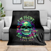 Black skull and flower print blanket on a gray sofa, neatly draped across cushions.