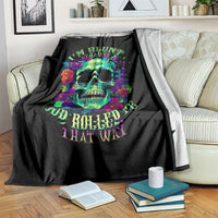 Black blanket with colorful skull and flower design, draped over a sofa arm.