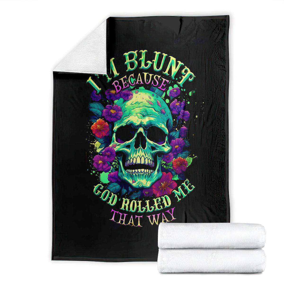 Black skull and flower artwork blanket with rolled white towels beside it.