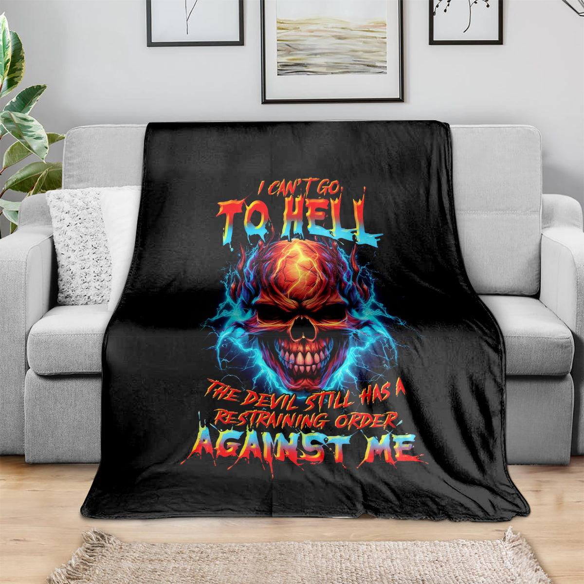 Black skull devil graphic blanket with colorful text design on a sofa