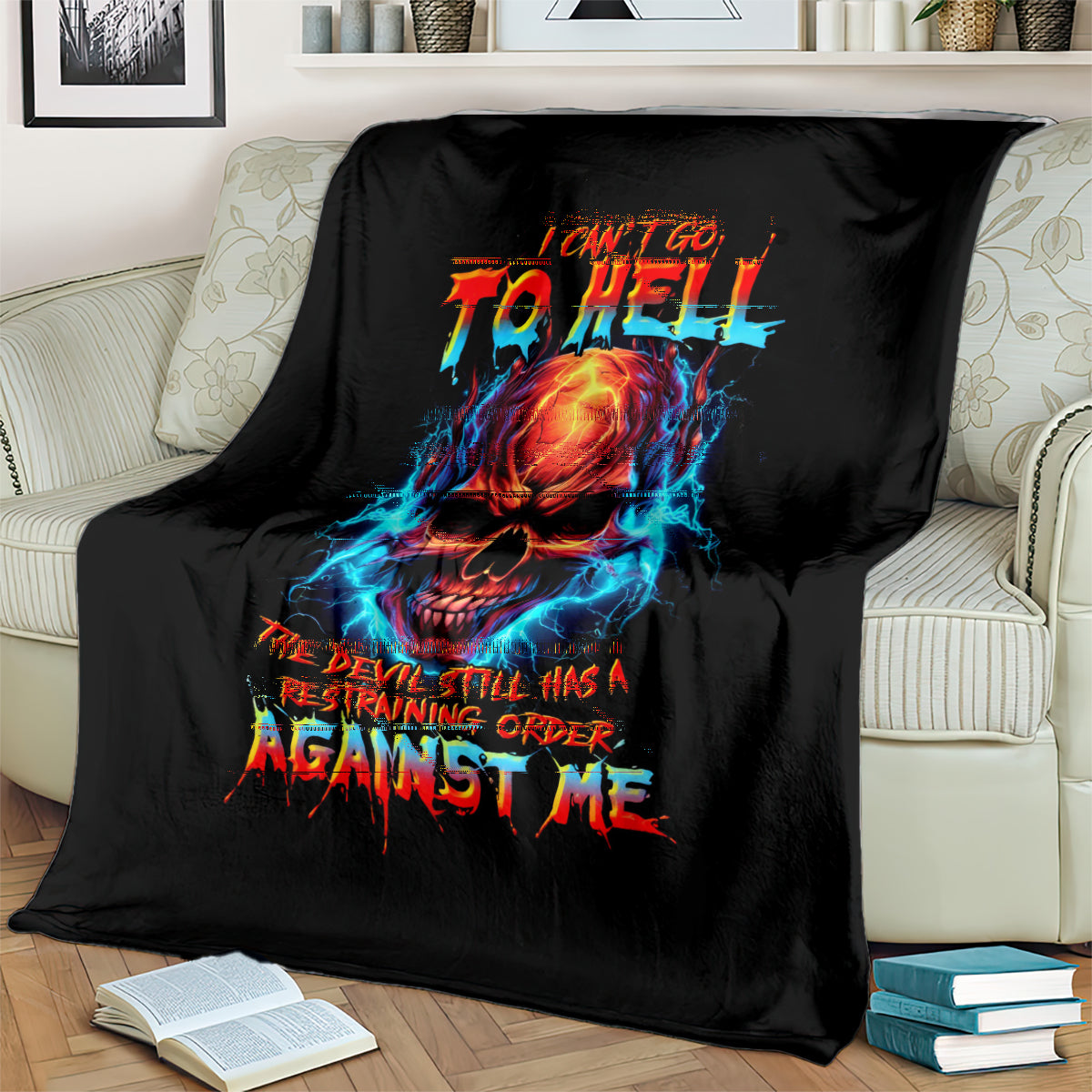 Black skull devil graphic blanket with multicolor flames and text, on a couch