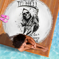 White round beach blanket with black reaper skull graphic and tassel fringe edge