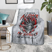 Grey throw blanket with devil skull graphic and red lettering, spread over sofa