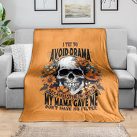 Orange throw blanket with smiling skull and orange floral graphic, on sofa