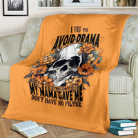 Orange skull-and-flower throw blanket with text graphic, draped over sofa