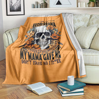 Orange blanket featuring skull and orange floral typography, draped across couch