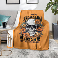 Orange throw blanket with skull and orange flowers graphic, on gray sofa