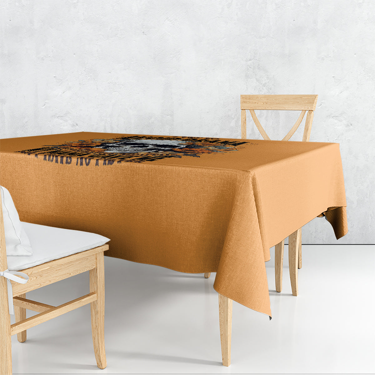 Orange tablecloth with floral skull graphic and fringe edge