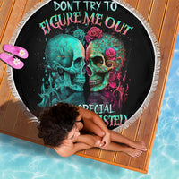 Black round beach blanket with white fringe edge and colorful twin skull graphic