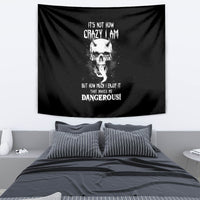 Black devil skull wall tapestry with white text and tongue graphic, reads “DANGEROUS!”