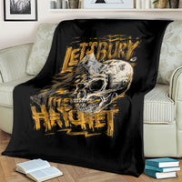 Black skull and axe graphic blanket with gold text, spread on couch