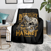 Black skull and axe graphic blanket with gold text, draped on sofa
