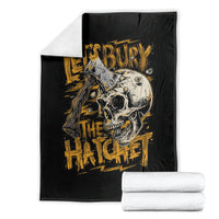 Black skull and axe graphic blanket with gold text, folded with white towels
