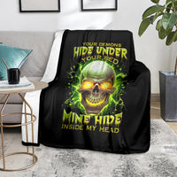 Black blanket on grey sofa with glowing green skull print and “Mine Hide Inside My Head”