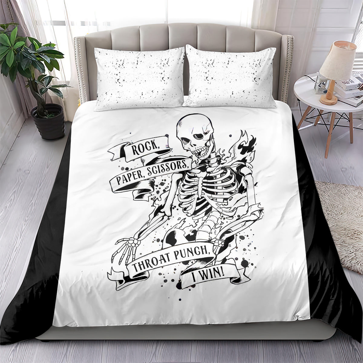 White bedding set with two pillows and black skeleton rock-paper-scissors graphic on duvet