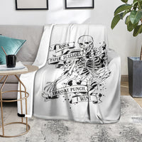 White skull graphic blanket on sofa with Rock Paper Scissors banner and 'Throat Punch' text