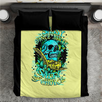 Yellow duvet cover with skull and turtle graphic, flanked by two black pillowcases