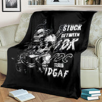 Black skull graphic throw blanket with white lettering, laid across a bed