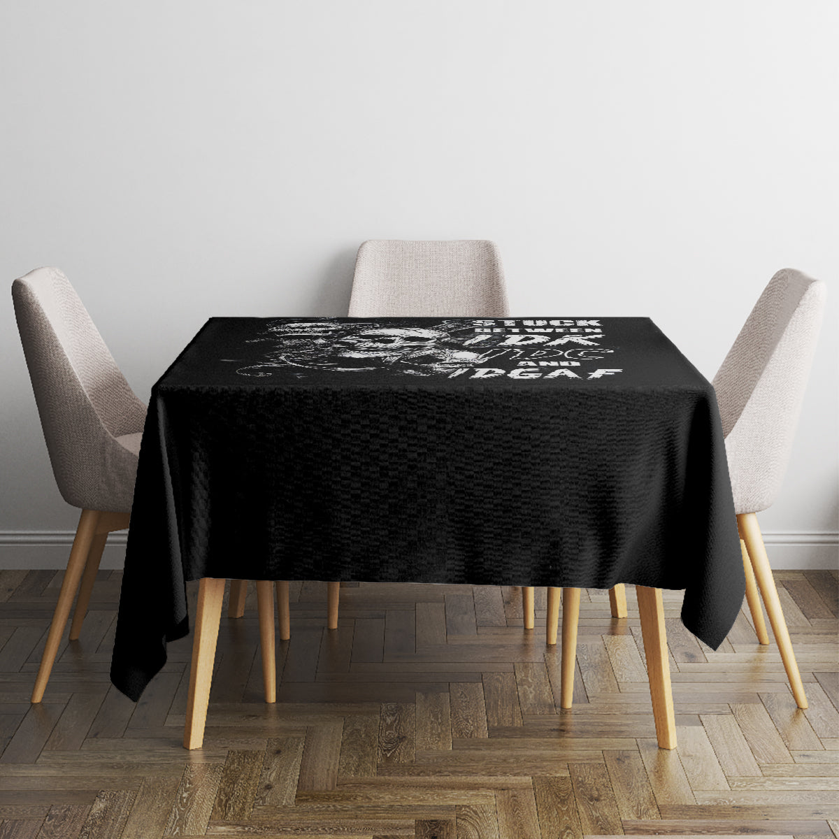 Black skull tablecloth covering a dining table with printed top section, corner folds visible.