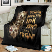 Black skull graphic throw blanket on a striped sofa, gold lettering and skull artwork