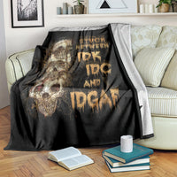 Black skull graphic throw blanket on a couch, with books and gold skull artwork