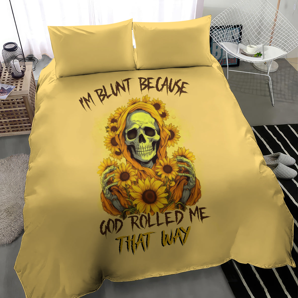 Yellow bedding set on bed with duvet and pillows; sunflower skull design and lettering.
