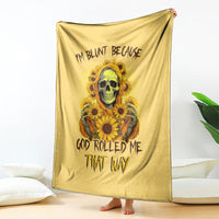 Yellow throw blanket with skull and sunflowers artwork, hanging vertically on the floor