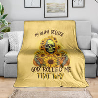 Yellow skull and sunflowers throw blanket with bold text graphic, draped on a sofa