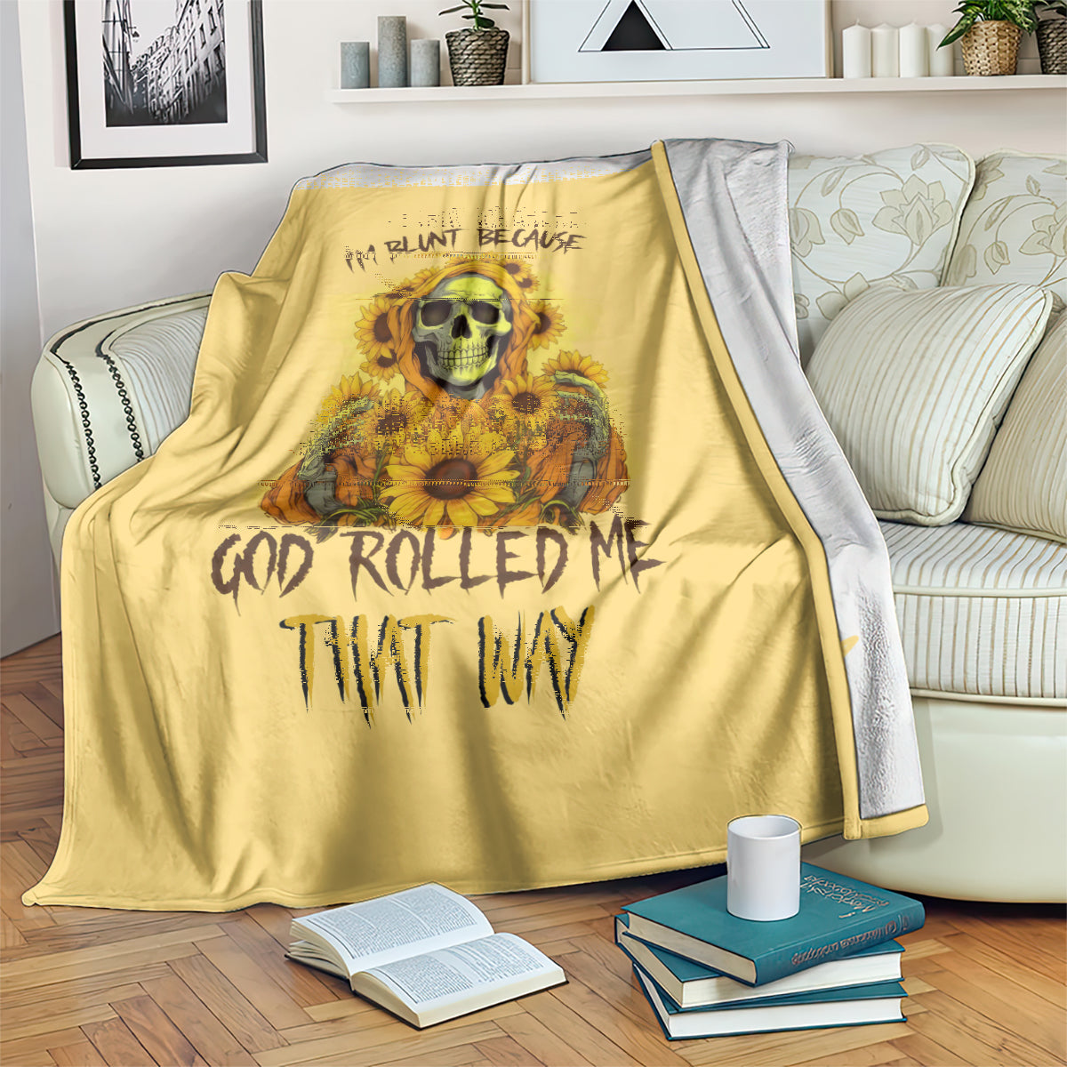 Yellow skull and sunflower throw blanket draped over a couch, with books on the floor
