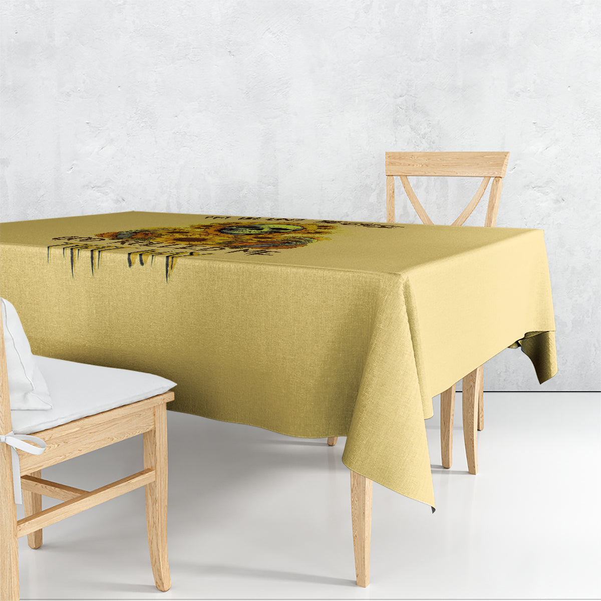 Yellow tablecloth with skull and sunflower graphic, draped over table edges.