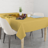 Yellow tablecloth on dining table with skull-and-sunflower graphic panel.