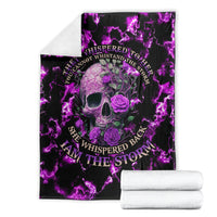 Purple skull and rose blanket with neon lightning design, stacked with folded towels