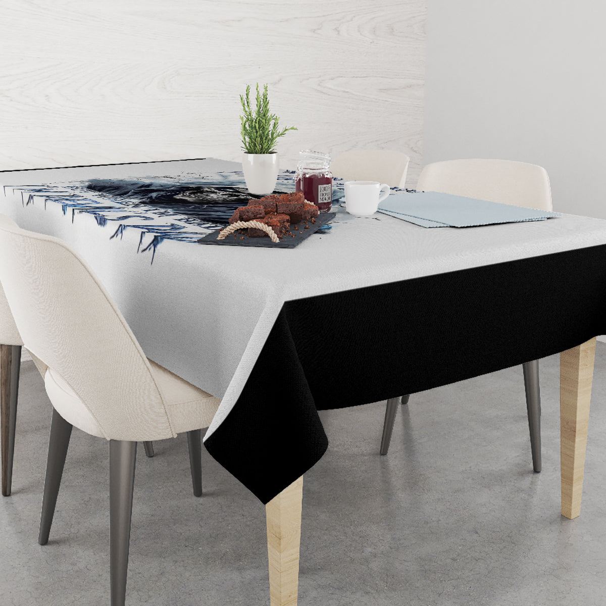 White tablecloth with blue skull graphic and text, table with folded corner