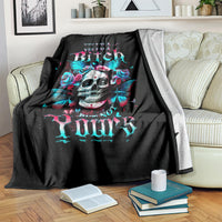 Black skull graphic blanket with butterfly-and-rose artwork, folded over chair arm