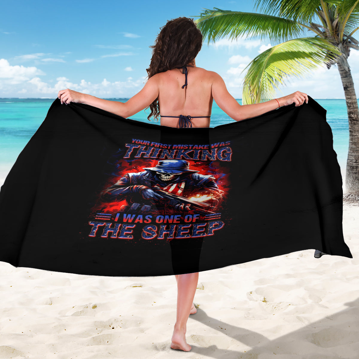 Black skull graphic sarong with wrap styling, worn like a beach cover-up