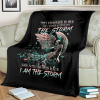 Black angel skull throw blanket on couch, teal winged design and 'I AM THE STORM'