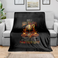 Black blanket with fiery skull graphic and slogan, draped on living room sofa