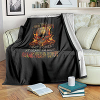 Black blanket with flaming skull graphic, draped across a bed