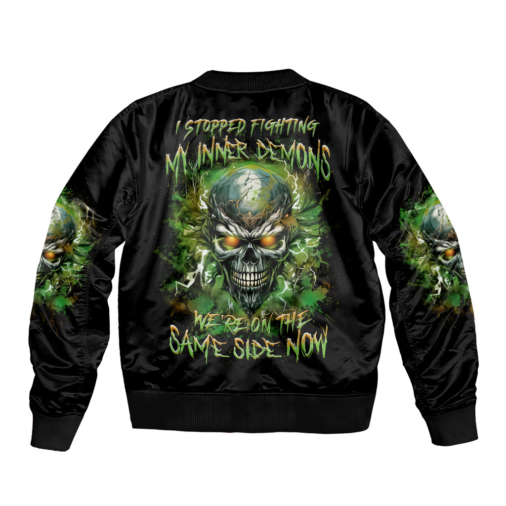 Black bomber jacket with ribbed trim and green skull graphic on the back.