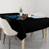 Black tablecloth draped over dining table with blue flame skull design and text