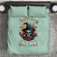 Mint blue bedding set laid flat with witch skull artwork and two pillowcases