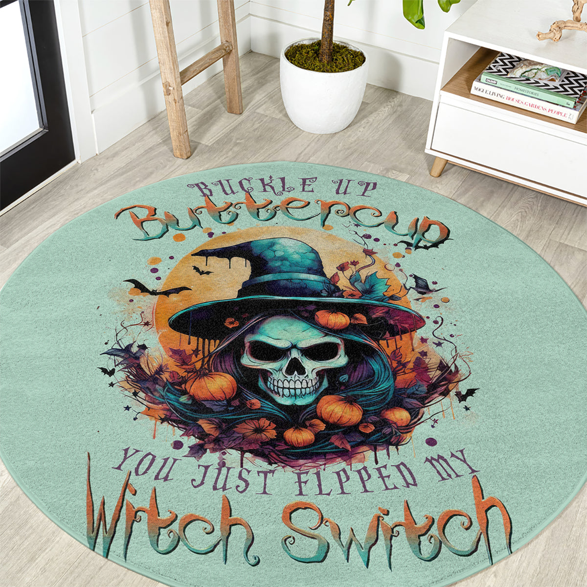 Teal round witch skull rug featuring a central skull in a black hat with orange pumpkins