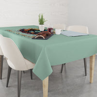 Mint green tablecloth draped on dining table with witch skull scene print