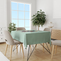 Mint green tablecloth on dining table featuring witch skull graphic across center