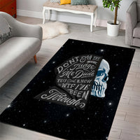 Black area rug with starry galaxy background, sad skull graphic and quote typography
