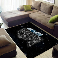 Black area rug with galaxy speckles, sad skull artwork and quote on center